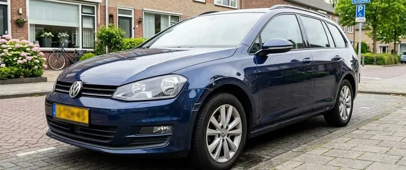 Donkerblauwe Volkswagen Golf Variant geparkeerd in een Nederlandse woonstraat met hortensia's op de achtergrond